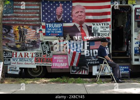 Bronx, United States. 23rd May, 2024. A Trump Store member sits outside the motorhome during a campaign event with former US President Donald Trump at Crotona Park in the Bronx. Credit: SOPA Images Limited/Alamy Live News Stock Photo