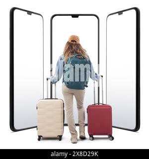 Young woman tourist traveling with trolley suitcase, rear view, looking smartphone screen front of her. Isolated on a white background. Concept of sum Stock Photo