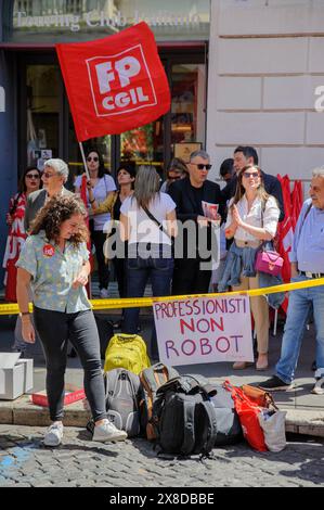 May 24, 2024, Rome, Italy: Protesters around the sign with the writing 'professionals not robots' and waving the CGIL union for the public service flag during the protest of the workers of the Territorial Commissions for International Protection and the National Commission for the right to asylum in Rome. The workers of the Territorial Commissions for International Protection and the National Commission for the Right of Asylum took to the streets to protest against the low quality of the service and because of the workload to which they are subjected, on the occasion of the strike called by th Stock Photo