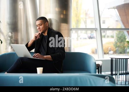 Pensive male freelancer sitting in cafe and working on laptop Stock Photo