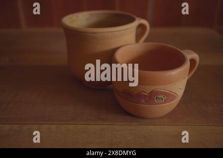 Empty earthenware mug on wooden table background. Stock Photo