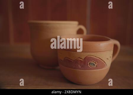 Empty earthenware mug on wooden table background. Stock Photo