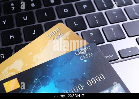 Two plastic credit cards on laptop, closeup Stock Photo