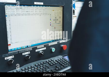 15.04.2024. Warsaw, Poland. Operator at the control console of CNC laser cutting machine. High quality photo Stock Photo