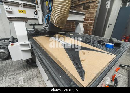 automatic milling machine working on the carbon fiber guitar at the workshop. High quality photo Stock Photo