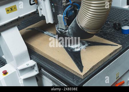 automatic milling machine working on modern carbon fiber guitar in the factory. High quality photo Stock Photo