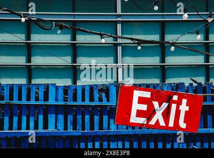A large exit sign on a blue wooden wall Stock Photo