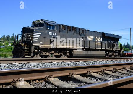 Stanwood, WA, USA - May 10, 2024; Norfolk Southern freight locomotive with train track and concrete railroad tie Stock Photo