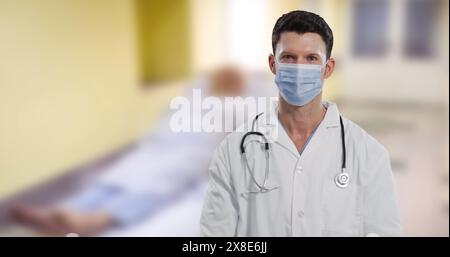 Image of caucasian male doctor over patient in hospital Stock Photo