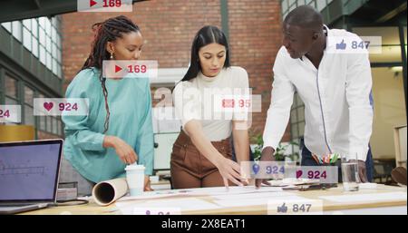 Image of icons and changing numbers in notification bars, diverse coworkers discussing blueprint Stock Photo
