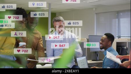 Image of notification bars over diverse coworkers using tablet, smiling and talking in office Stock Photo