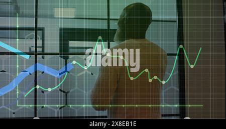 African American senior manager analyzing financial graphs on glass wall Stock Photo
