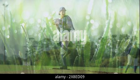 Biracial child in baseball gear stands on pitcher's mound, glove in hand Stock Photo