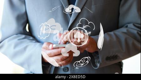 Caucasian middle-aged man in suit holding smartphone, interacting with digital icons Stock Photo