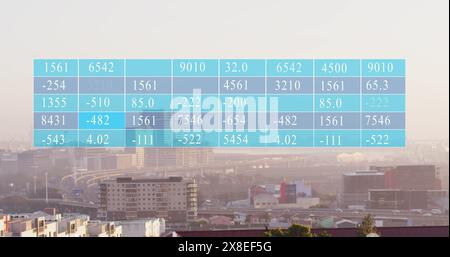 Image of numbers in table over modern cityscape against sky Stock Photo