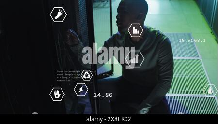 Image of digital icons, data processing on african american male engineer working at server room Stock Photo