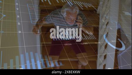 Image of graphs and numbers, senior caucasian man sitting on staircase and talking on cellphone Stock Photo