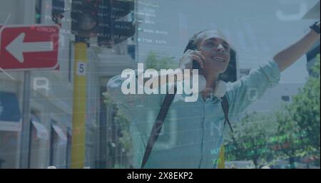 Image of graphs, trading board, changing numbers, letters, biracial man raising hand to stop cab Stock Photo