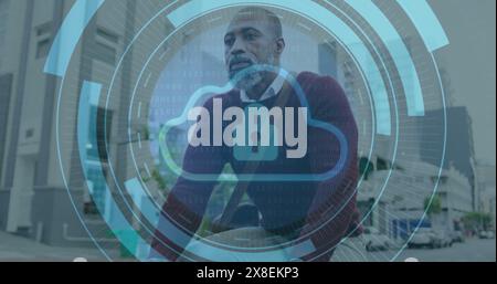 Image of cloud in loading circles, senior thoughtful african american man sitting outdoor Stock Photo