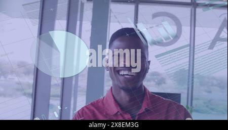 Image of financial data processing over smiling african american businessman in office Stock Photo