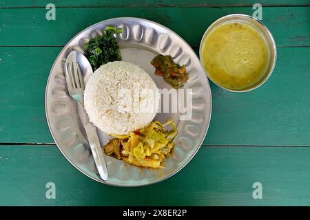 A Nepalese-style dal bhat, a traditional meal of steamed rice, cooked lentil stew and seasonal vegetables, served with pickles at a trekking lodge Stock Photo