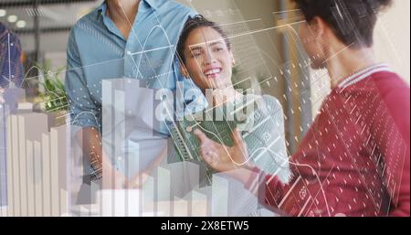 Image of graphs, loading circles, changing numbers, diverse coworkers talking in office Stock Photo