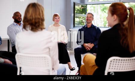 People Consoling Man In Group Therapy Session Stock Photo