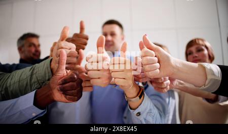 People's Hand Showing Thumb Up Sign In Office Stock Photo