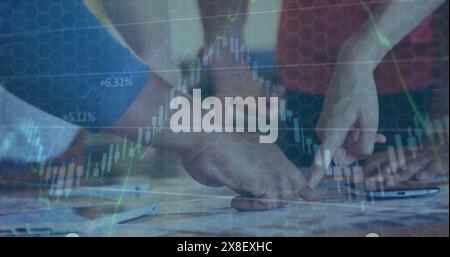 Image of graphs moving over diverse hands of business people pointing at report on desk Stock Photo