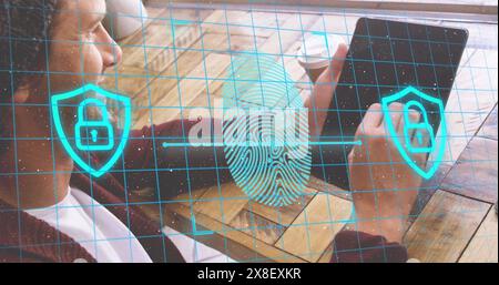 Image of fingerprint and padlock in shields over caucasian man scrolling on digital tablet Stock Photo