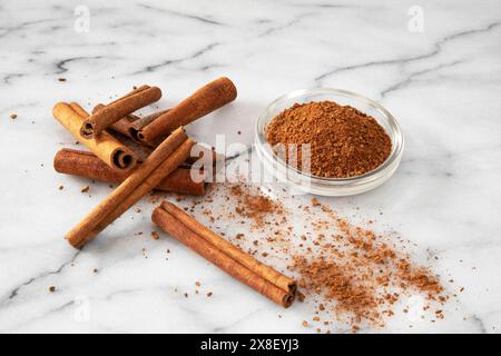 Close-up of cinnamon sticks and powder on a white marble background Stock Photo