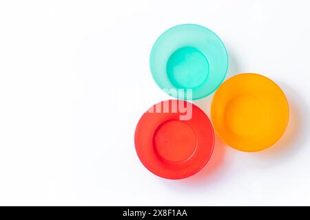 Vibrant plastic tableware set isolated on white background with copy space. Top view. Stock Photo
