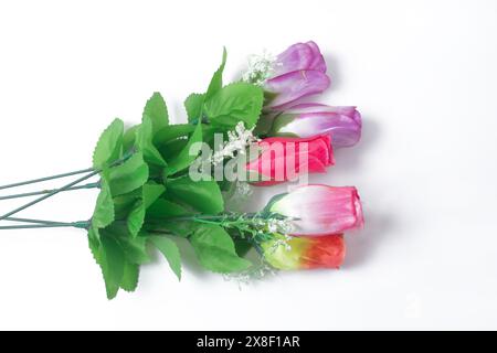 Colorful bouquet of artificial roses with green leaves on white background, space for text Stock Photo