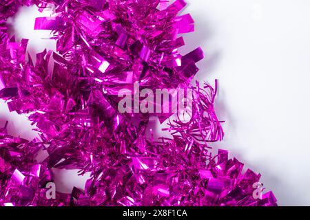 Vibrant pink tinsel garland on white background. Festive decoration Stock Photo