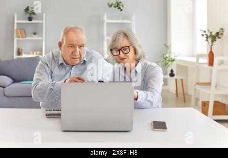 Elderly Couple Working Together on Laptop at Home Stock Photo
