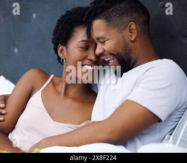 Black couple and bed with embrace or smile for love, together and laugh on weekend morning. Dating, comfort and relaxing with passion for partner with Stock Photo