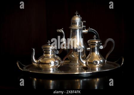 old antique polished silver coffee set against dark black wooden background for aristocracy and old rich money concept in Villa Necchi Campiglio, Mila Stock Photo