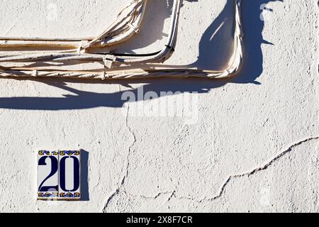Number twenty and light wires on a whitewashed Alhambra facade Stock Photo