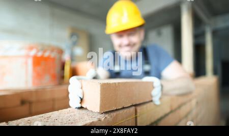 Male smiling builder puts make brickwork Stock Photo