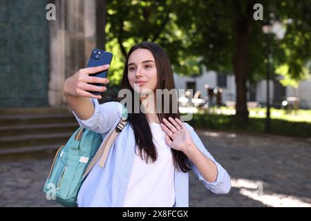 Beautiful travel blogger with smartphone streaming outdoors Stock Photo