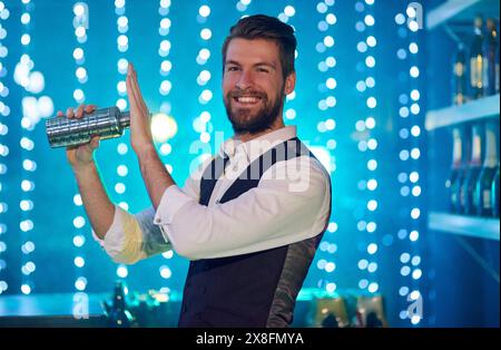 Portrait, bartender and shaking cocktail with pride for nightclub, bar and mixing drinks with happiness. Man, professional and smile for party, event Stock Photo