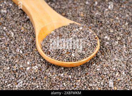 Scattered chia seeds with wooden spoon close up Stock Photo