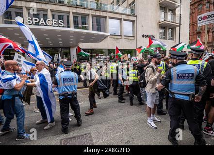 Protesters clash with police. Palestian protest blocked by pro Israel demonstration. The Palestian protest faced off the pro Israel protest in Manchester city centre's St Peter's Square. The Palestinian march then attempted to march down Oxford road Manchester but were prevented by the Pro Israel protest. Police intervened with protesters pushing but being kept apart. Eventually the march was allowed to pass with Police keeping the two sides apart. Some police drew their batons and used them to control the crowd. Manchester UK. Picture: gary Roberts/worldwidefeatures.com Stock Photo