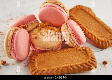 A selection of colorful macarons and delicate lotus cookies displayed on a table, showcasing a variety of baked goods perfect for finger food at any e Stock Photo