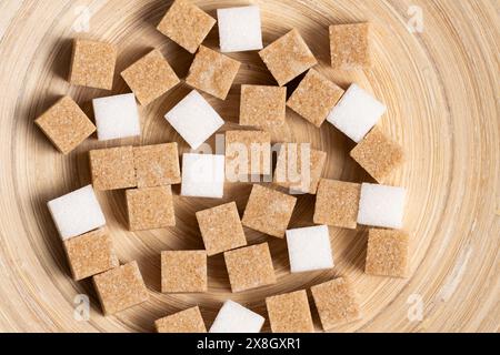 Cubes of cane and white refined sugar on wooden background Stock Photo