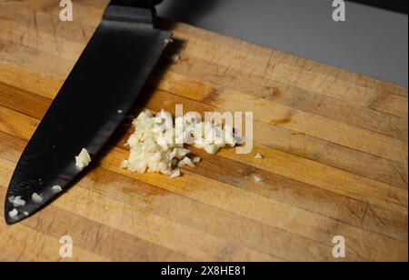 Chopped garlic on a wooden cutting board. Studio, above shot Stock Photo