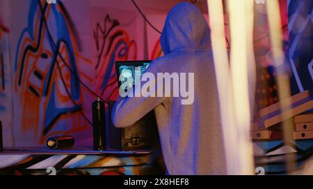 Close up shot of hacker in underground bunker using network vulnerabilities to exploit servers, trying to break computer systems at night. African American cybercriminal breaching networks Stock Photo