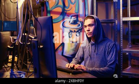 Hacker group coordinating DDoS attack on website, working on multiple computers to sending large amounts of traffic and overwhelm it. Rogue programmers in secret bunker flooding target server Stock Photo