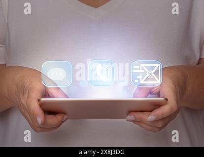 Female hands holding a tablet with holograms. Choice Stock Photo