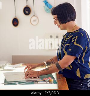 Craftswoman, light table and designer drawing in studio, working and creative professional with cutting mat for measurements. Woman, sketch and Stock Photo